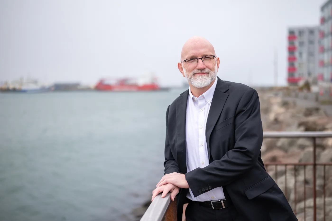 Gísli Rafn Ólafsson leaning on a railing by the harbor
